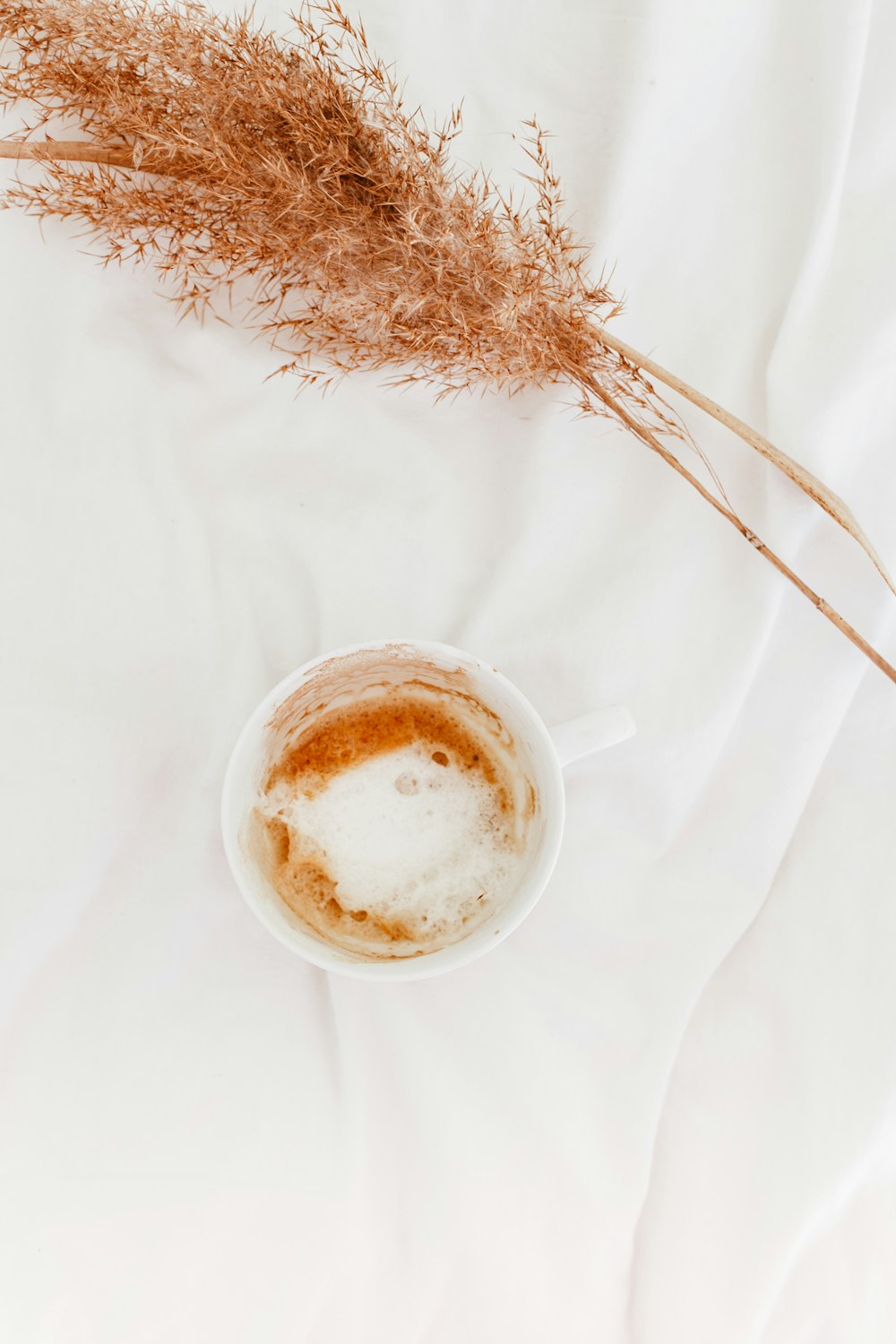 white ceramic mug with brown liquid