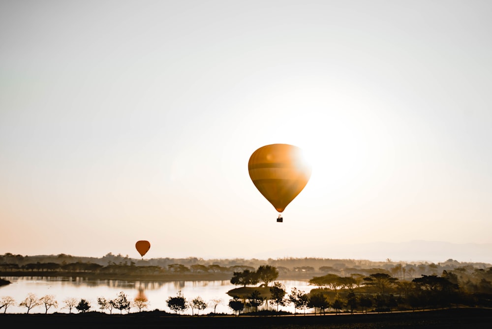 hot air balloon flying over the sea during daytime