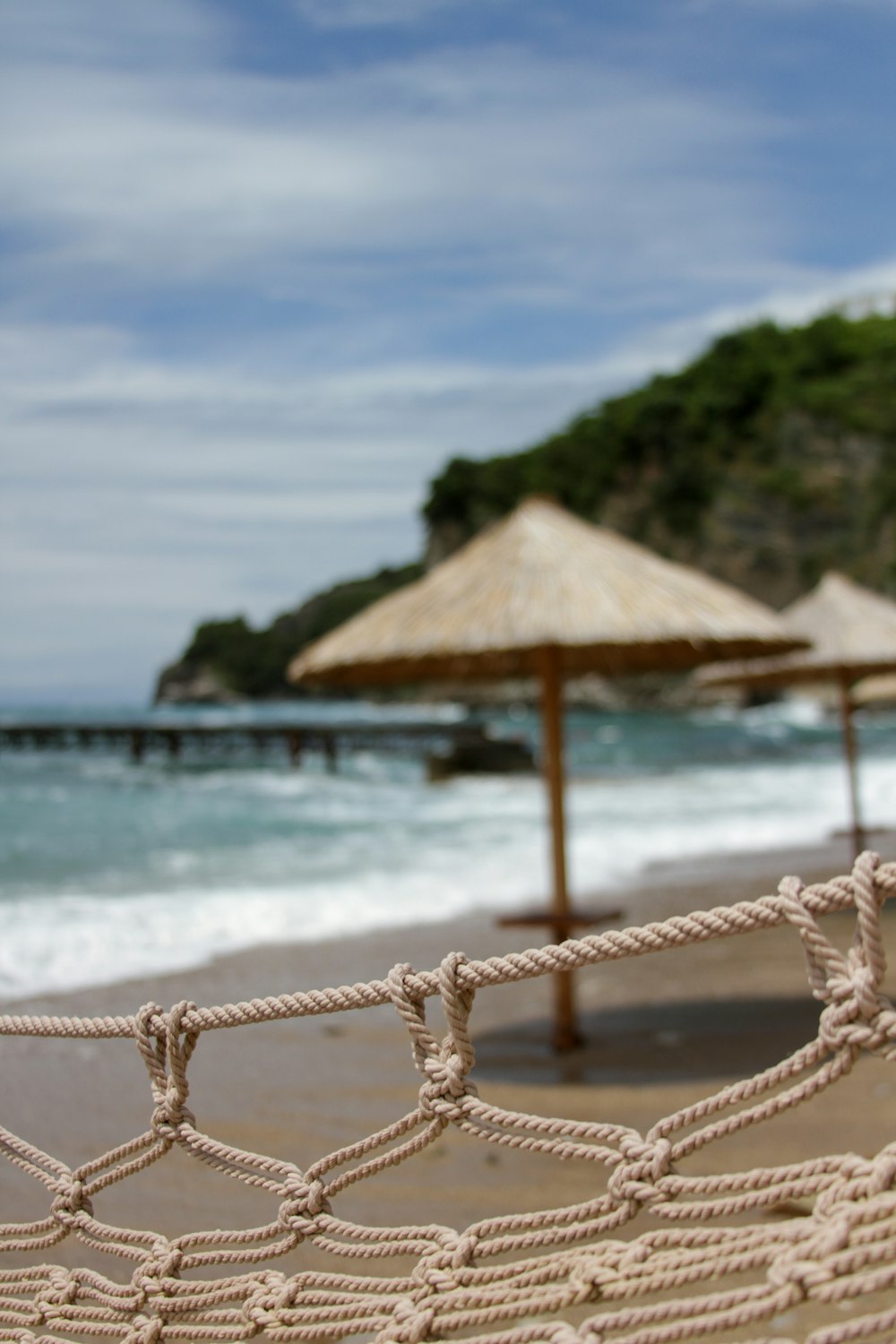 brown wooden beach umbrellas on beach during daytime
