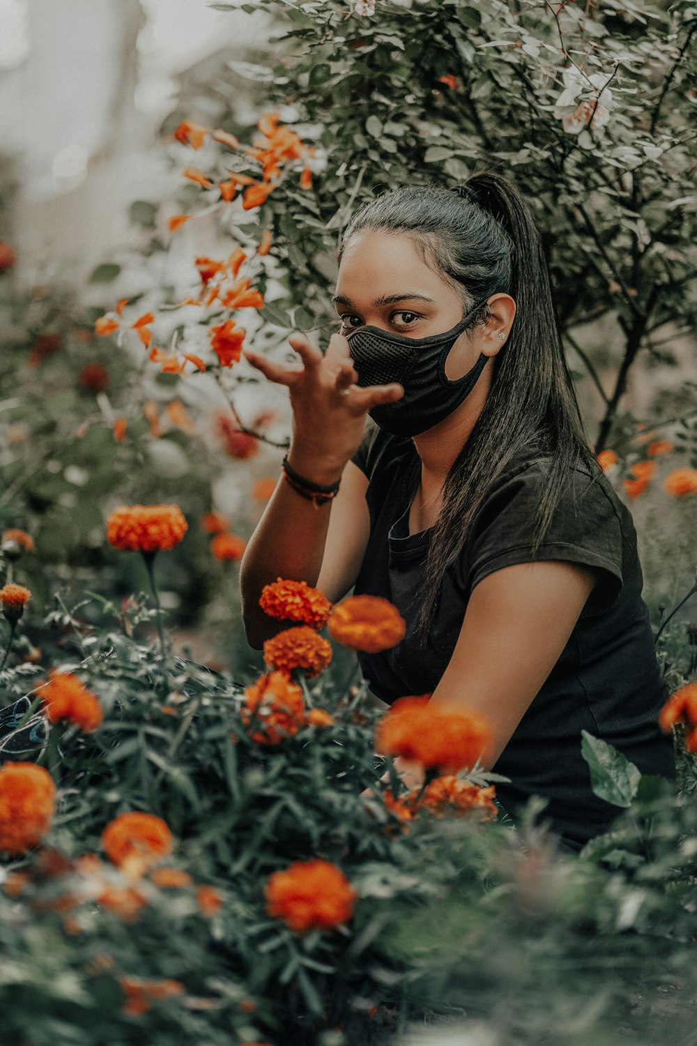 woman in black t-shirt covering her face with her hand