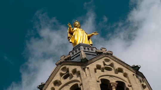 gold statue of man on top of building in La Basilique Notre Dame de Fourvière France