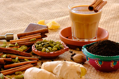 Close-up of premium rajwadi masala tea leaves and spices arranged artfully on a rustic wooden table.