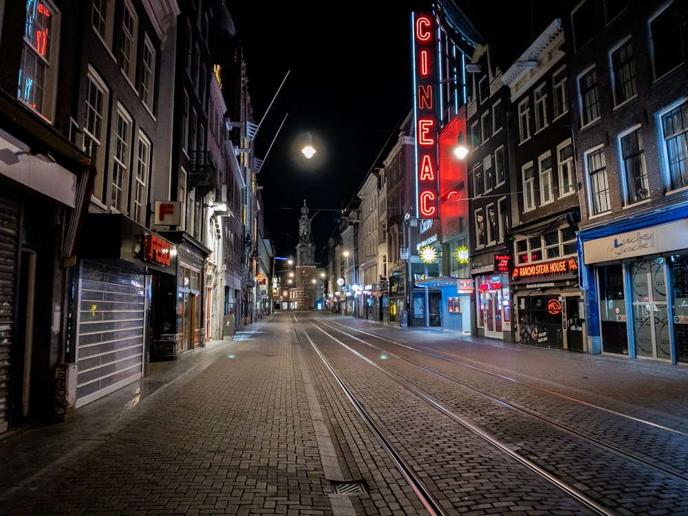 cars on road between buildings during night time