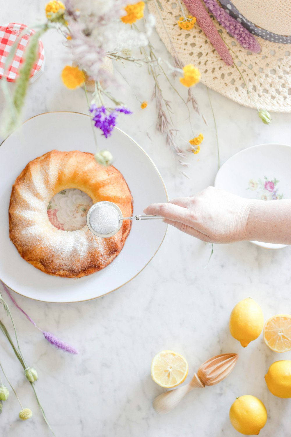 Person, die Donut auf weißer Keramikplatte hält