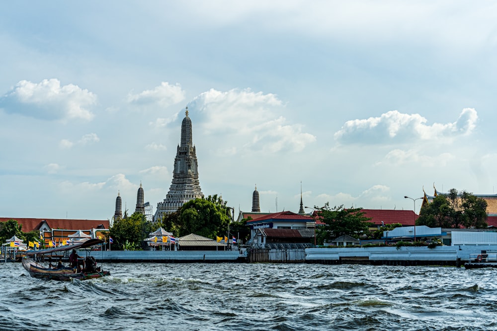 body of water near brown and white building under white clouds during daytime