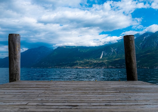 brown wooden dock on body of water during daytime in Parco dell'Alto Garda Bresciano Italy