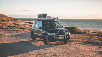 black mercedes benz g class suv on brown sand during daytime