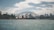 The iconic Sydney Opera House and the Sydney Harbour Bridge are prominently featured, with surrounding waters and a skyline of urban buildings under a partly cloudy sky.