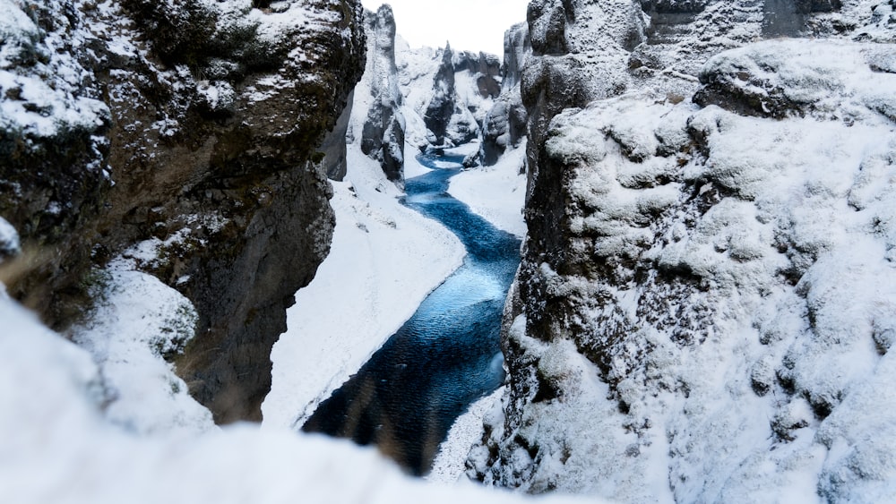 昼間の灰色の岩山の間の水域