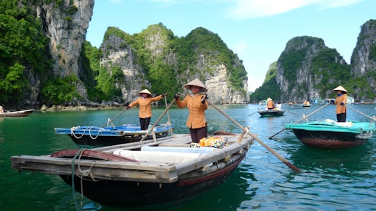 man in brown shirt and blue denim jeans riding on boat during daytime in Halong Bay Vietnam