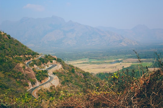 aerial view of road between green mountains during daytime in Munnar India