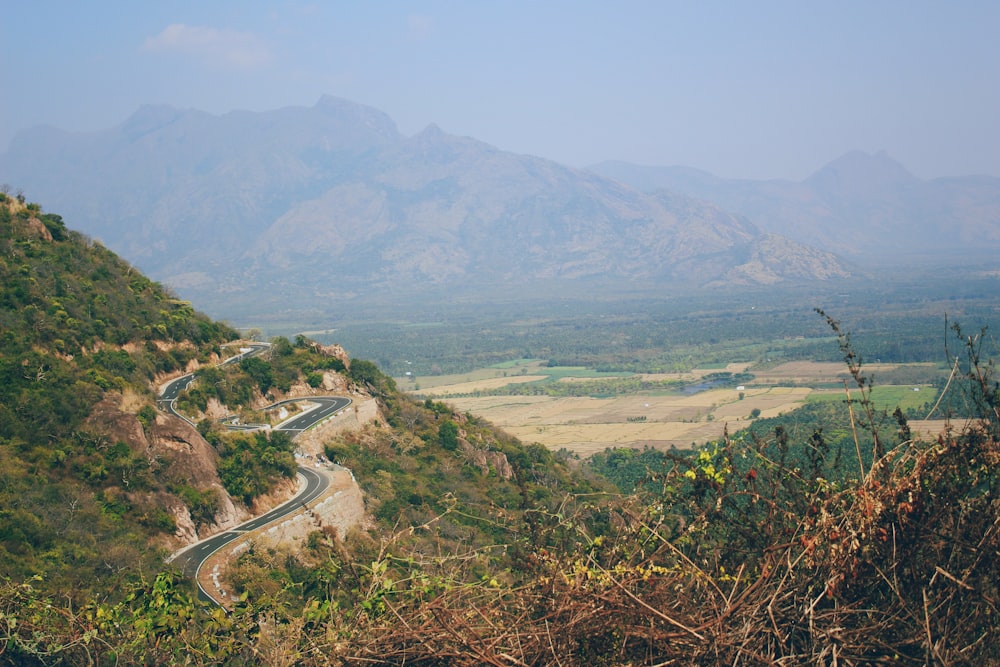 aerial view of road between green mountains during daytime