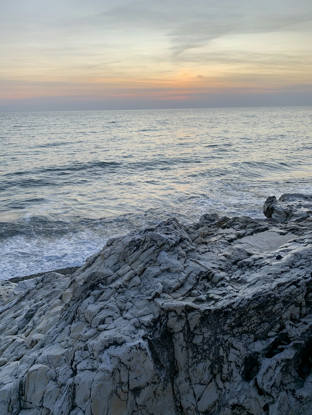 black rock formation near sea during sunset