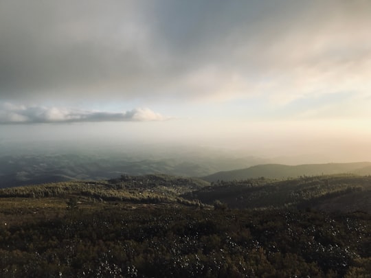 green mountains under white clouds during daytime in Foja Portugal