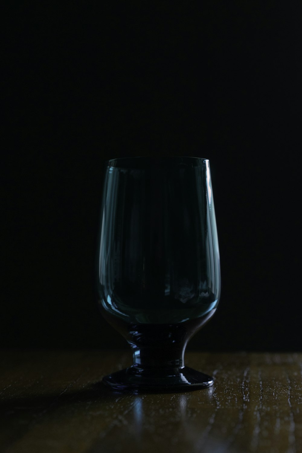 blue drinking glass on brown wooden table