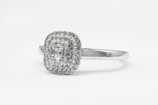 silver diamond studded ring on white surface