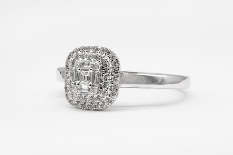 silver diamond studded ring on white surface