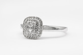 silver diamond studded ring on white surface