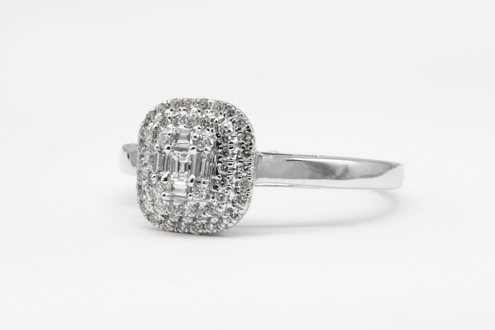 anello in argento tempestato di diamanti su superficie bianca