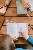 A friendly tutor and a high school student engaged in an English literature discussion with books and notes spread out.