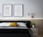 Close-up of a modern minimalist framed wall art hanging above a neatly made bed.