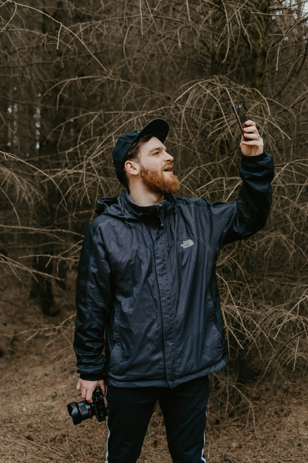 man in black jacket standing on brown field during daytime