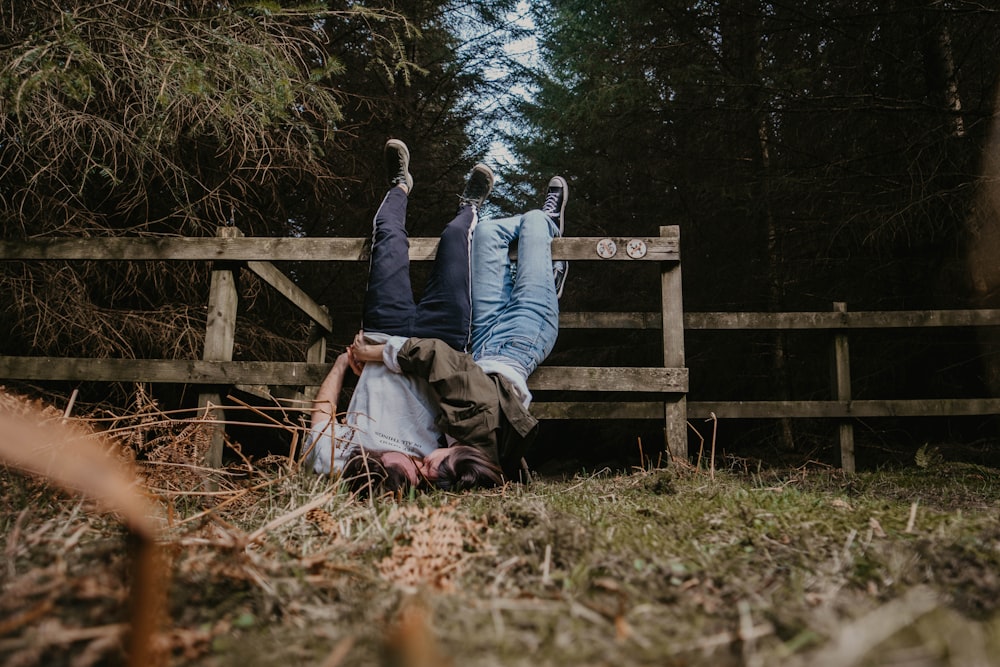 man and woman sitting on brown wooden bench