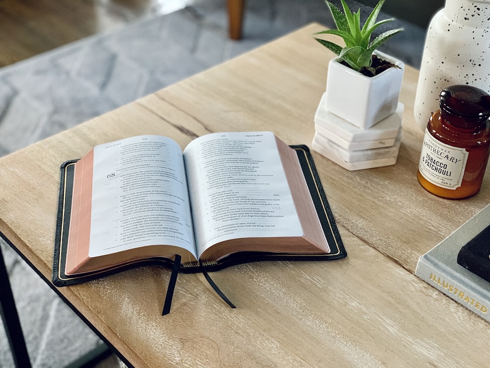 opened book on brown wooden table