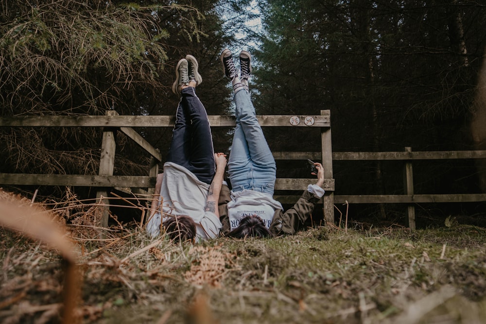 man and woman sitting on brown wooden fence during daytime