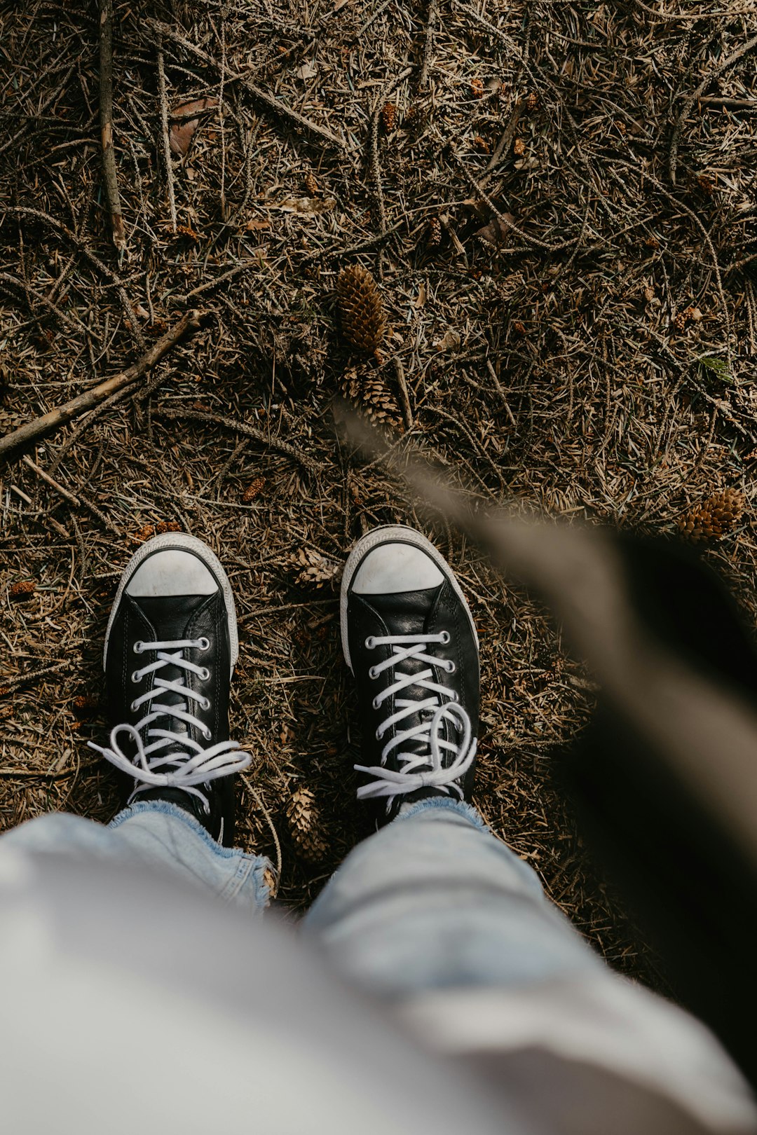 person in blue denim jeans and black and white sneakers