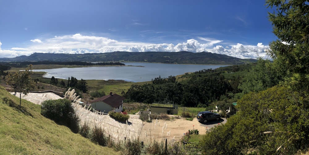 black car parked near green trees and body of water during daytime