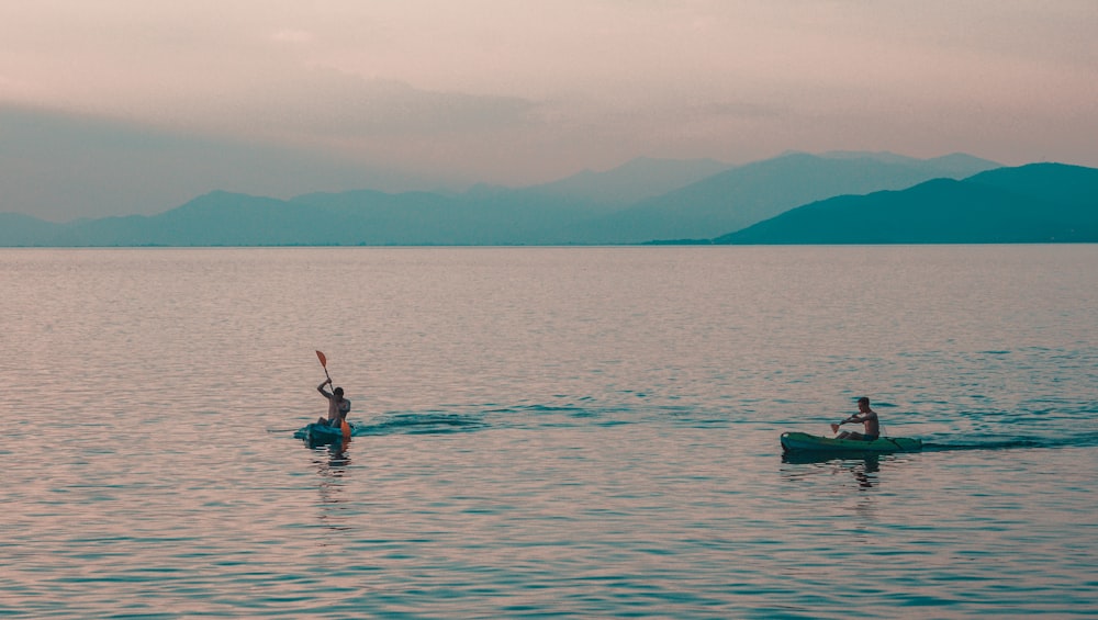 homme en chemise rouge équitation sur le kayak vert sur la mer pendant la journée