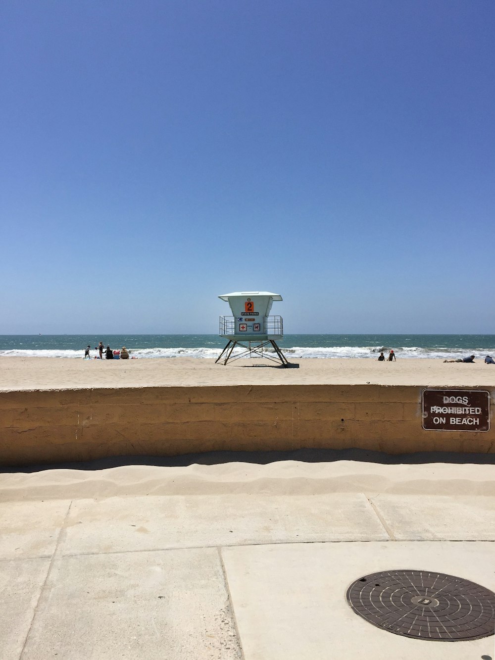 white lifeguard house on beach shore during daytime