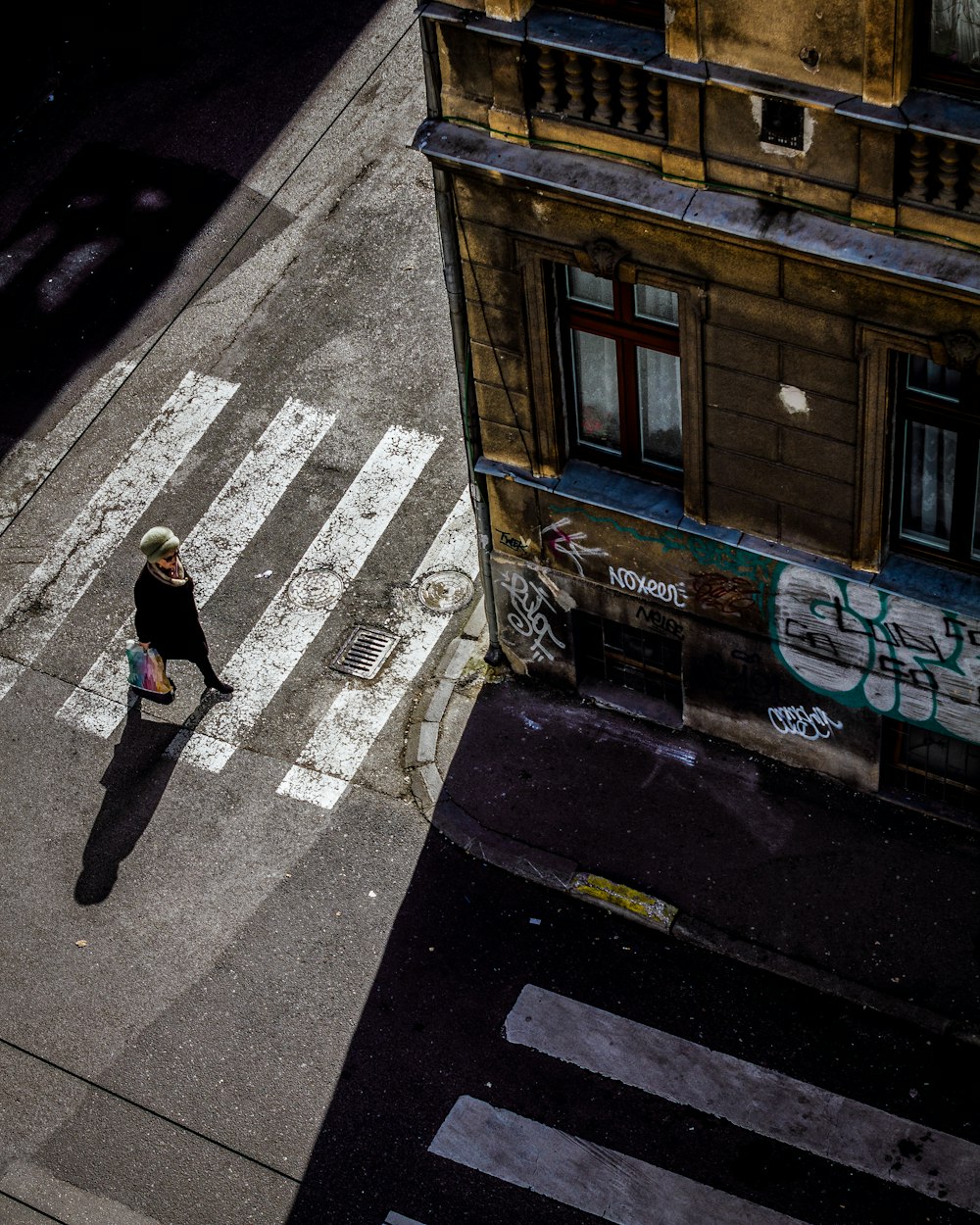 man in black jacket walking on sidewalk during daytime