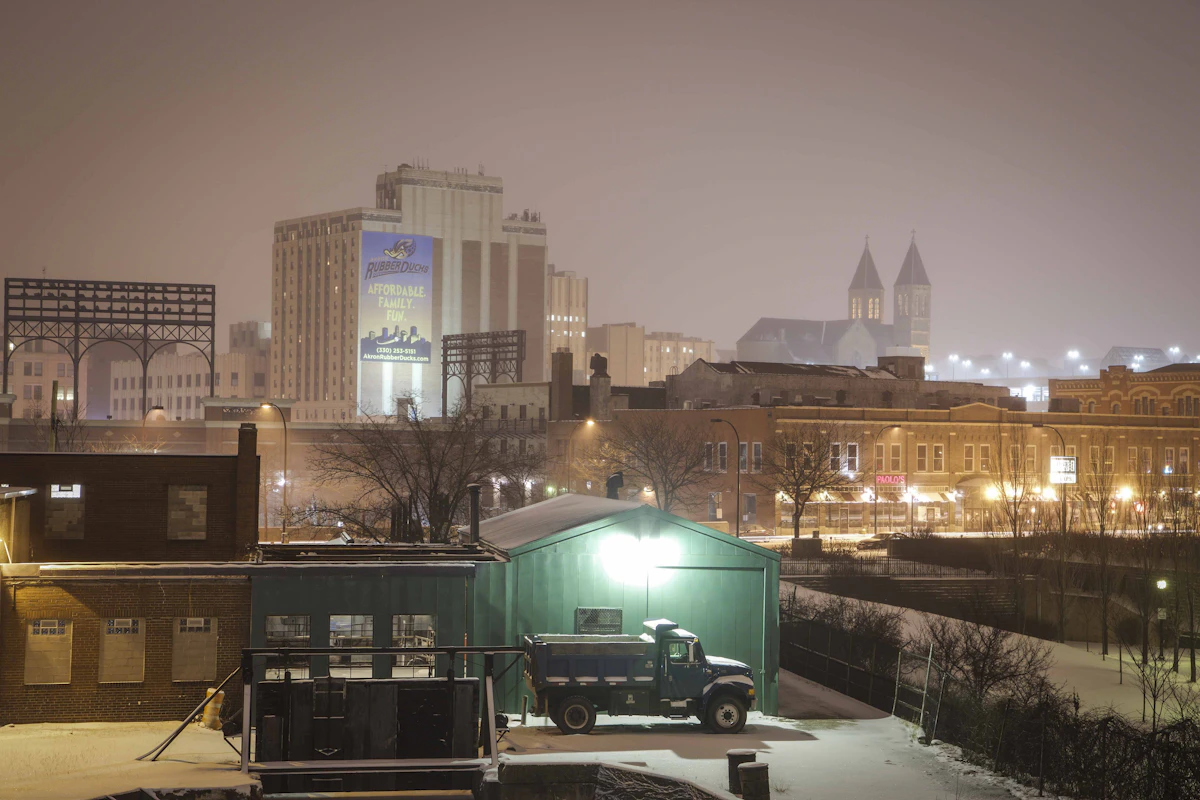 Akron buildings and an illuminated industrial foreground at night