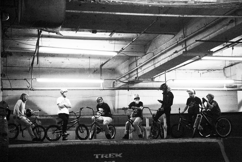 grayscale photo of people riding bicycle