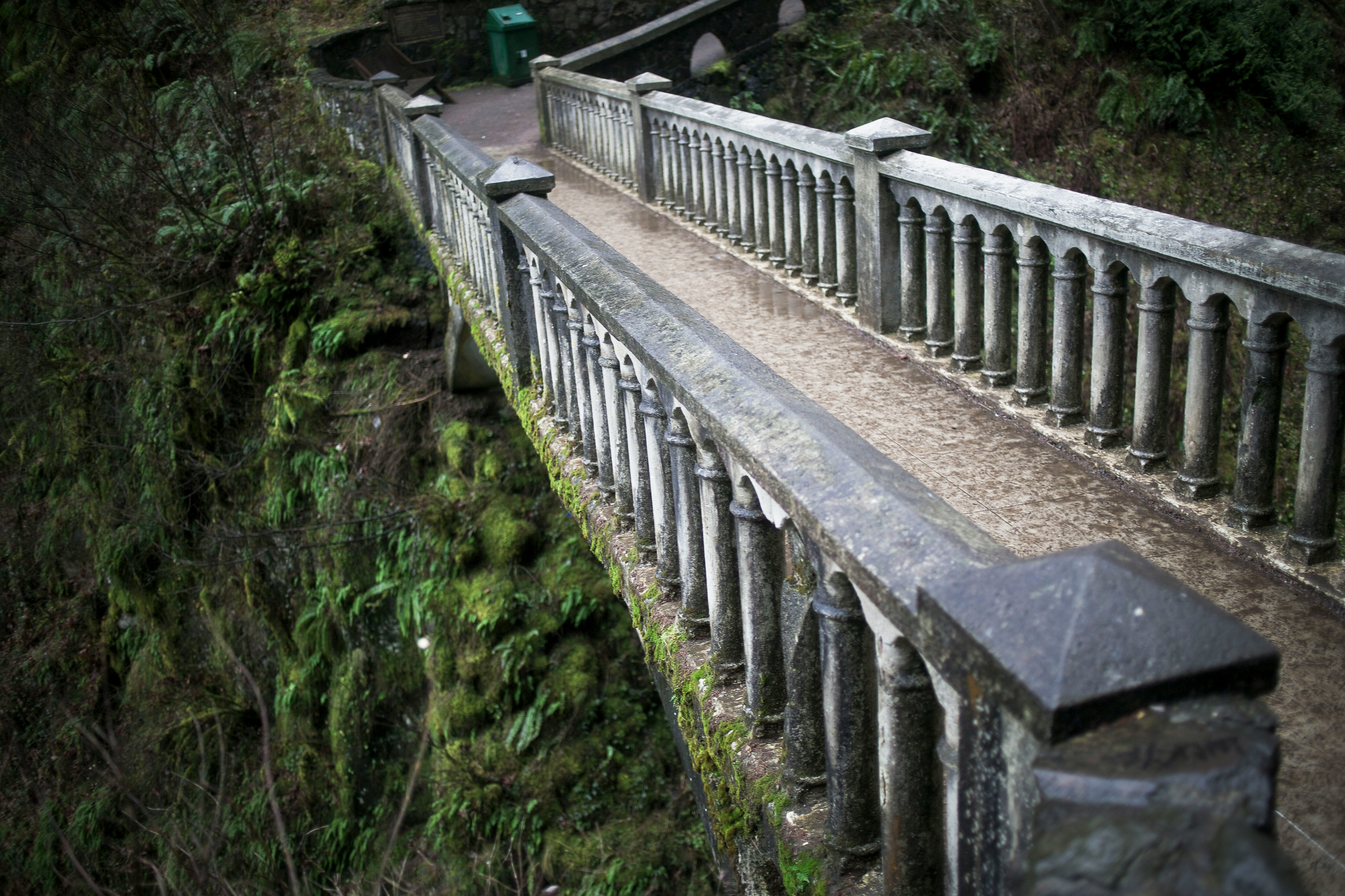 gray concrete bridge over green grass field during daytime