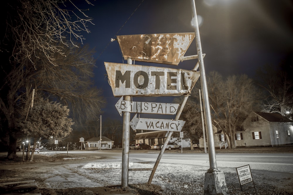 a motel sign sitting on the side of a road