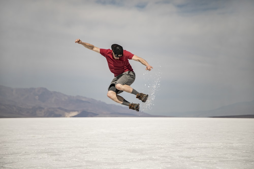 man in black shirt and black pants doing stunts on snow covered ground during daytime