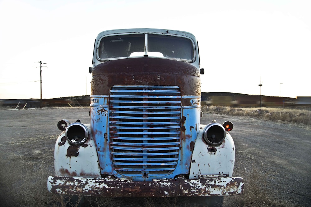 blue and white vintage car on road during daytime