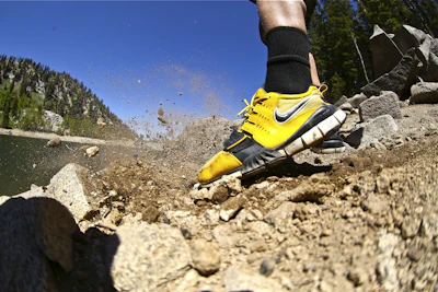 person wearing yellow and black nike athletic shoes