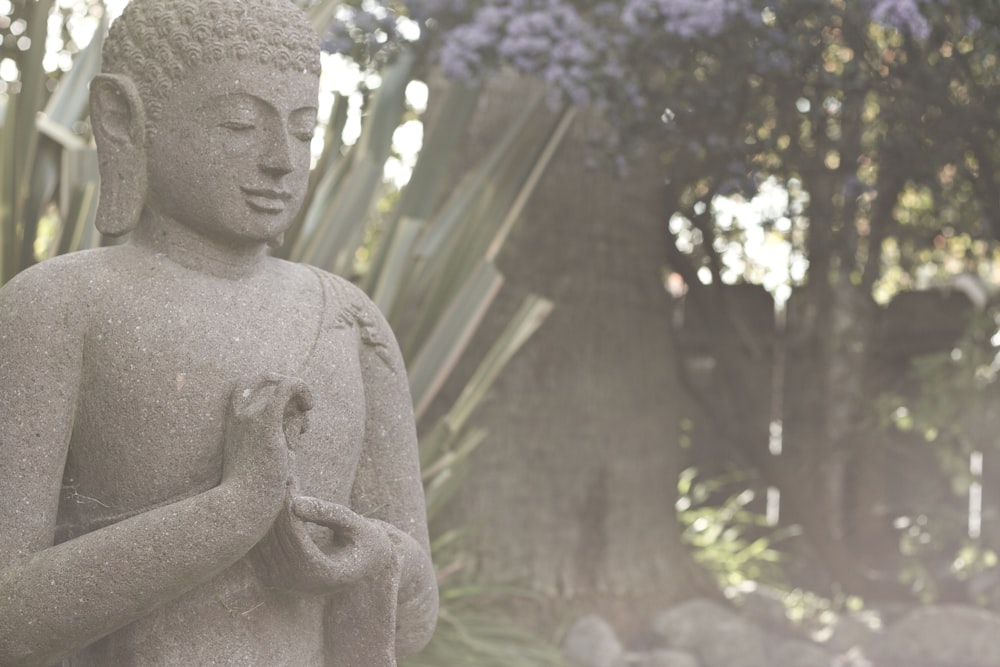 gray concrete statue near green trees during daytime