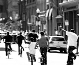 A group of diverse employees riding electric bikes in a city.