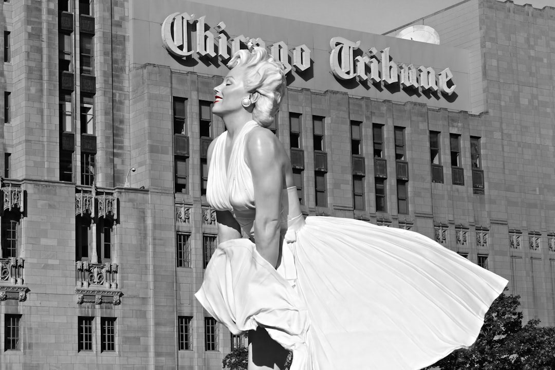 grayscale photo of woman in dress statue