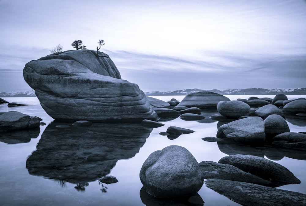 gray rock formation on body of water during daytime