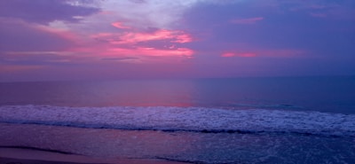 A tranquil beach at sunset with gentle waves lapping the shore.