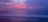 A tranquil beach scene at sunset with gentle waves.