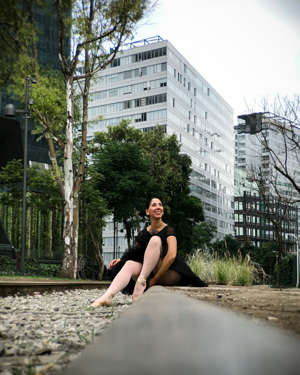 woman in black tank top sitting on gray concrete floor