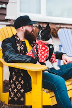 Hombre sostiene a perro vestido con ropa hecha a mano, elegante y divertido