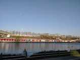 A fleet of brand-new buses lined up at the export dock under a clear blue sky.